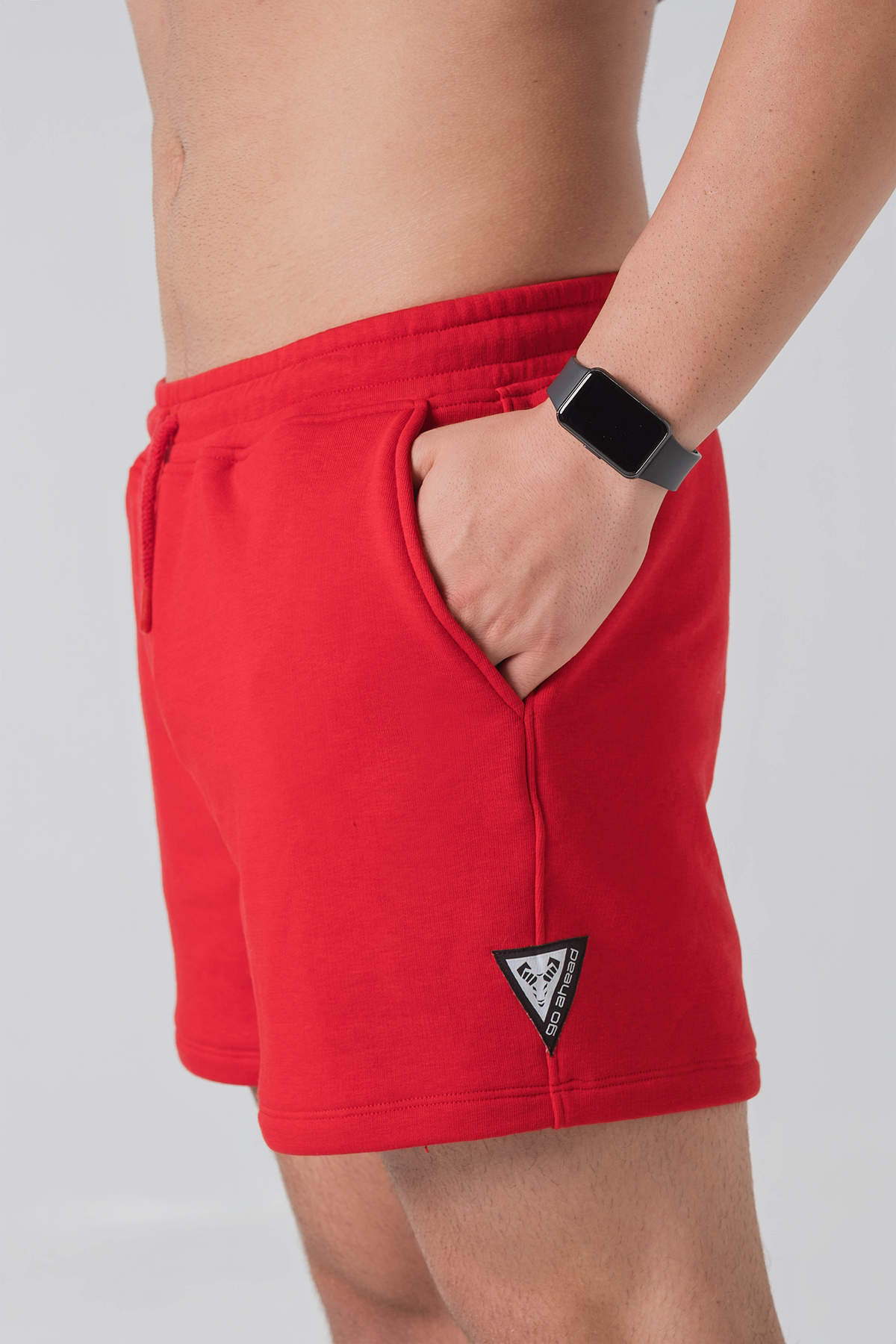 Pantallona të shkurtra District – Pantallona të shkurtra sportive/casual për meshkuj në ngjyrë të kuqe, me brez elastik me spango rregulluese (drawstring), xhepa anësorë, një xhep në pjesën e pasme dhe stemë me logon trekëndëshe Dominer në pjesën e poshtme anësore.