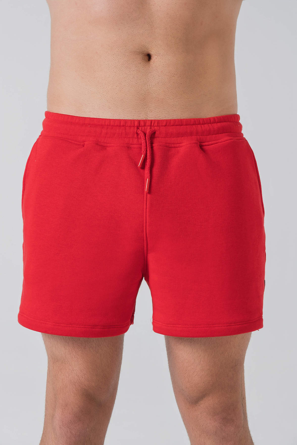 Pantallona të shkurtra District – Pantallona të shkurtra sportive/casual për meshkuj në ngjyrë të kuqe, me brez elastik me spango rregulluese (drawstring), xhepa anësorë, një xhep në pjesën e pasme dhe stemë me logon trekëndëshe Dominer në pjesën e poshtme anësore.
