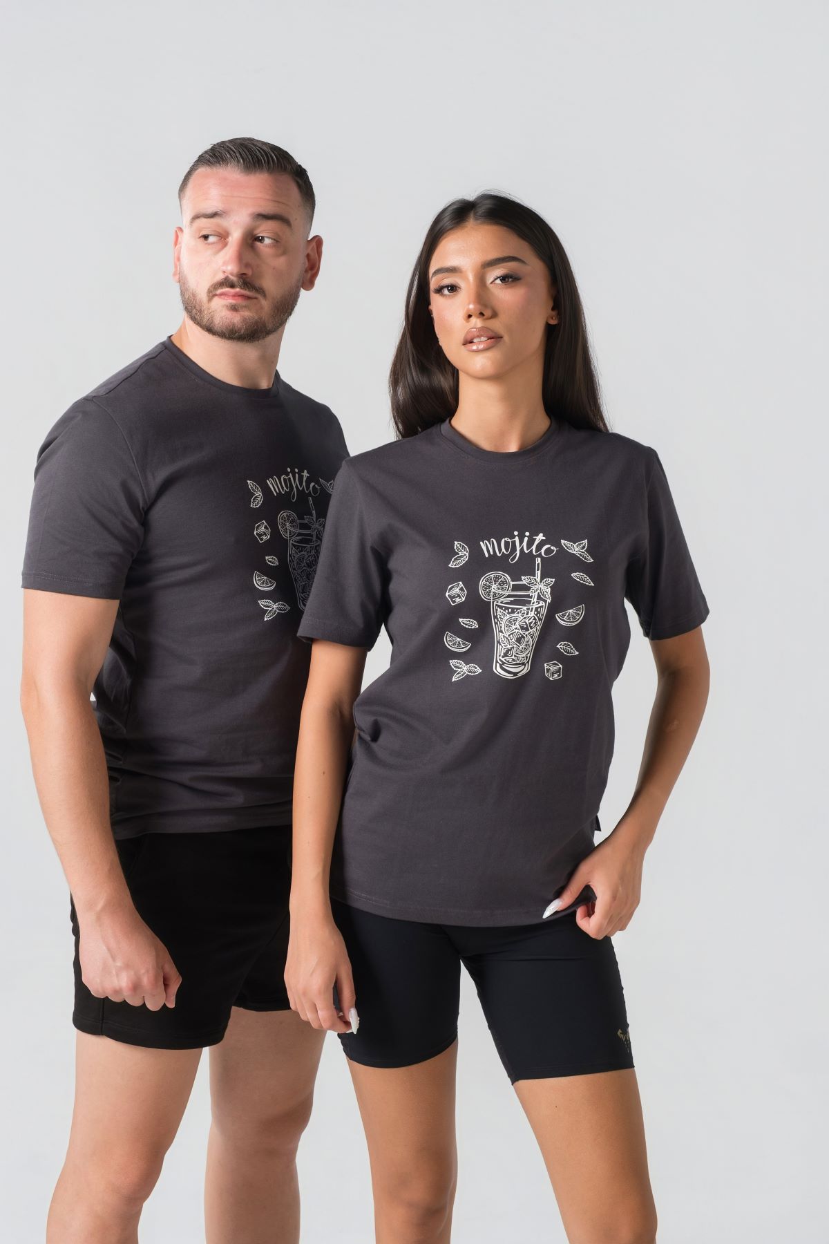 T-shirt Breezy Unisex – Bluzë e thjeshtë me mëngë të shkurtra unisex në ngjyrë hiri të mbyllur (dark grey/charcoal), me jakë të rrumbullakët, print grafik veror me koktej "Mojito" me gjethe horteze/nenexhiku dhe akull në ngjyrë të bardhë në gjoks.