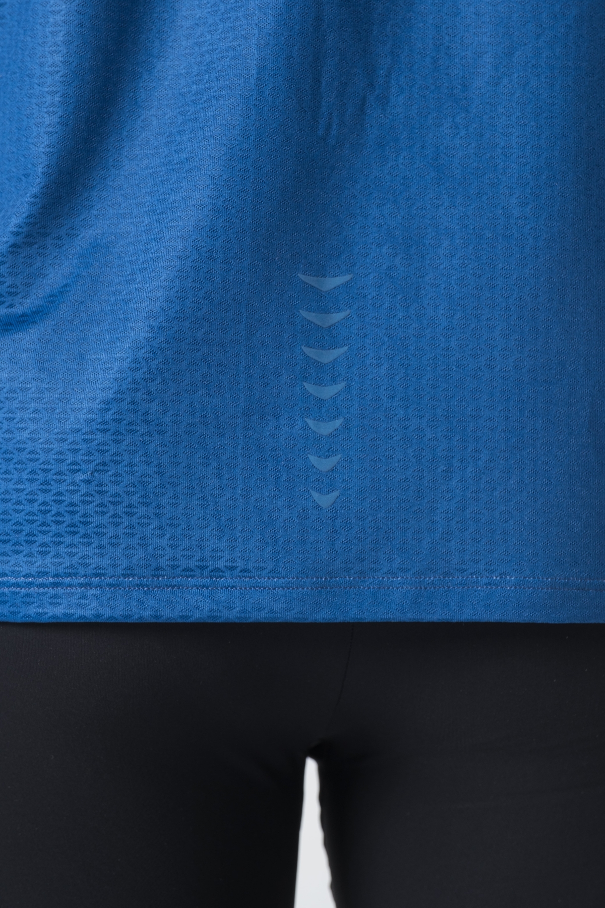 Shift Bluze Meshkujsh – Bluzë sportive me mëngë të shkurtra për meshkuj në ngjyrë të kaltër mbretërore (royal blue), me jakë të rrumbullakët, prerje anësore me të çara të vogla në fund, material me teksturë rrjetë prapa dhe në mëngë për ajrosje, logo minimale Dominer në gjoks, emrin e markës të printuar në pjesën e pasme sipër dhe detaj vertikal me shigjeta në pjesën e poshtme prapa.